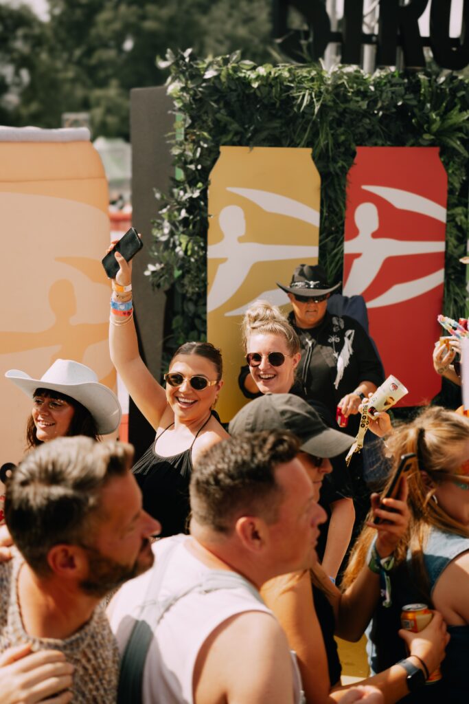 Two members of the PG team smiling and having a good time at Brighton Pride, surrounded by other people and with the Strongbow logo behind them.