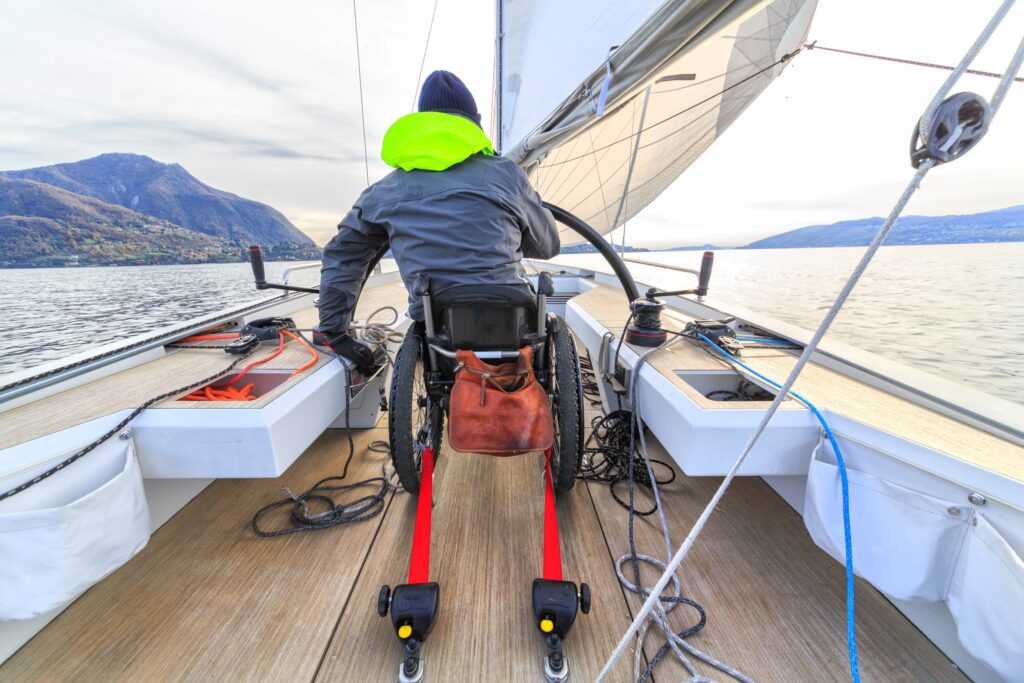 A picture of a wheelchair user driving a boat on a lake.