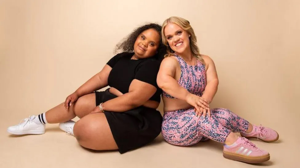 Ellie Simmonds sits with another petite model as they model clothes from the new range by Dewey