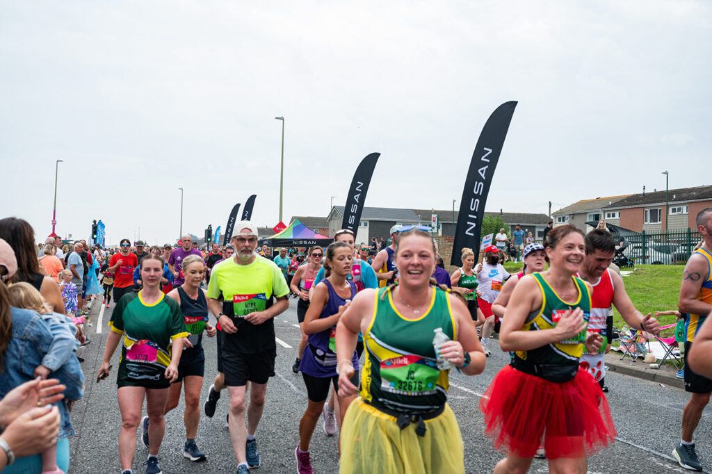 A group of runners going down a road in a suburban area as part of the Run to the Future Race.