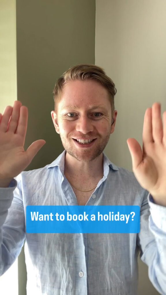 Luke Christian signs while telling his audience about his TUI Accessible Holiday experience. The caption on the screen reads: "Want to book a holiday?"