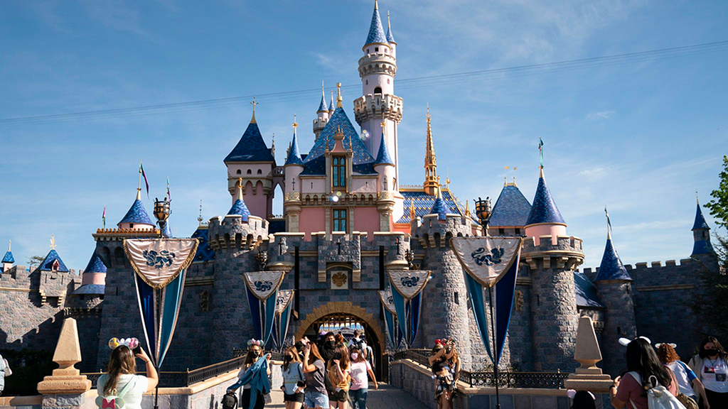 The Sleeping Beauty Castle at Disneyland California with visitors going into it.