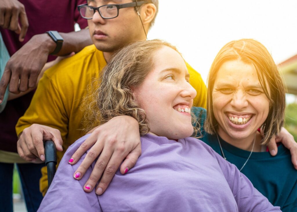 Two People Hugging And Smiling Outside In The Sun